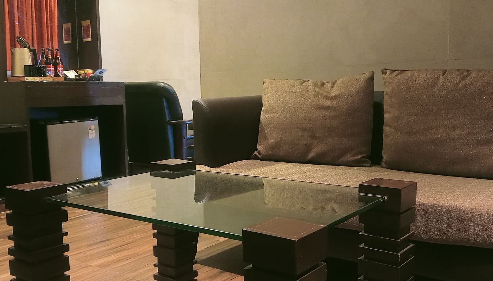 image of the centre table with a beige coloured couch behind it at the artist suite at grand palce yercaud