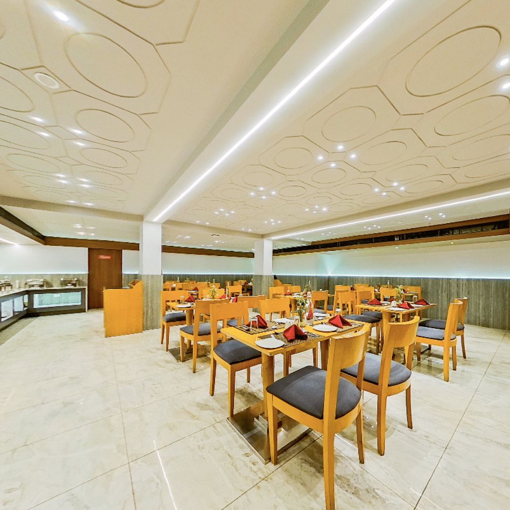 Spacious dining hall featuring buffet counter and multiple seating areas at Lords Eco Inn Dahej, with elegant marble columns and decor