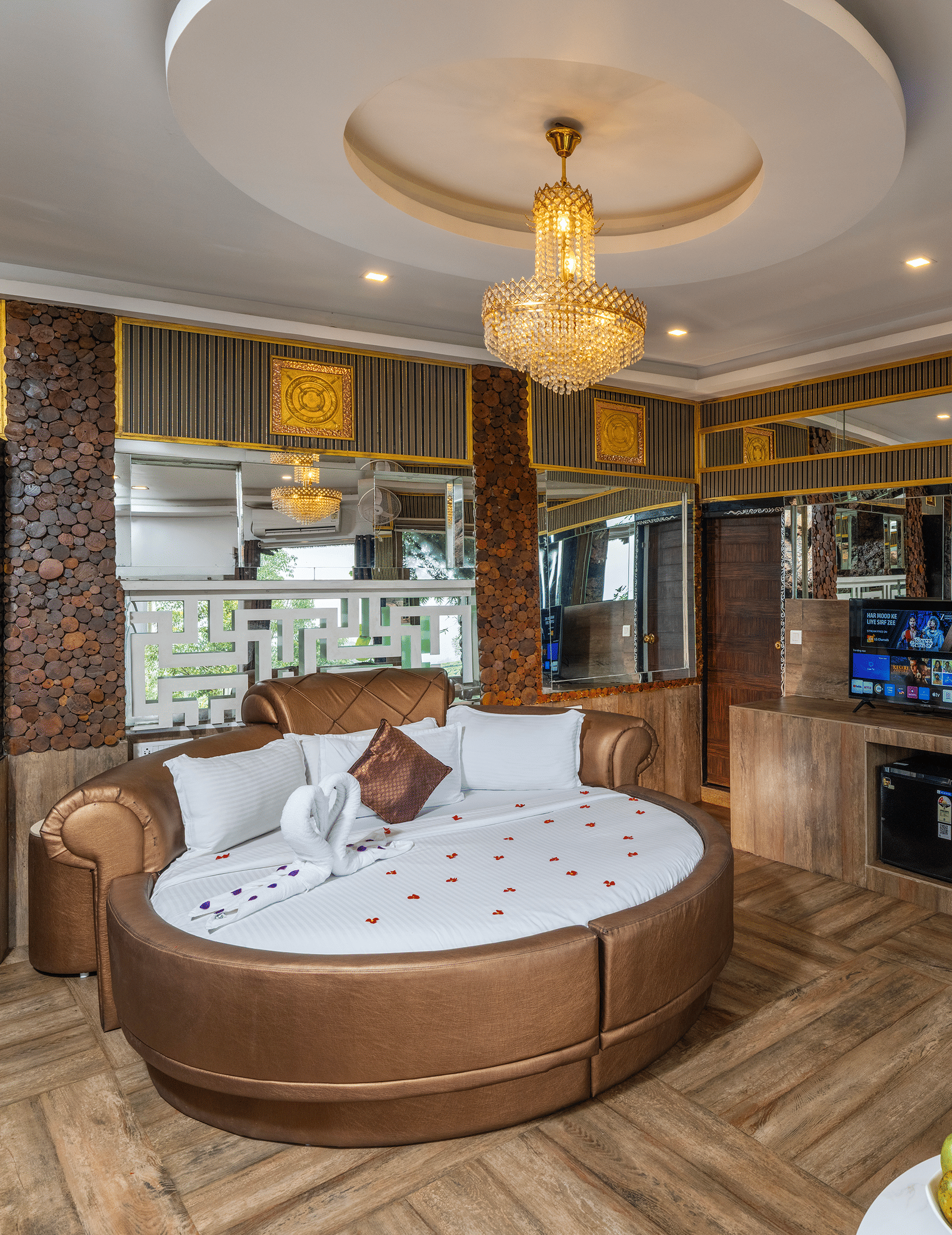 A bedroom in Single Bedroom Pool Villa at Parakkat Nature Hotel and Resorts featuring a round bed, a chandelier, coffee table, and patterned tiles.