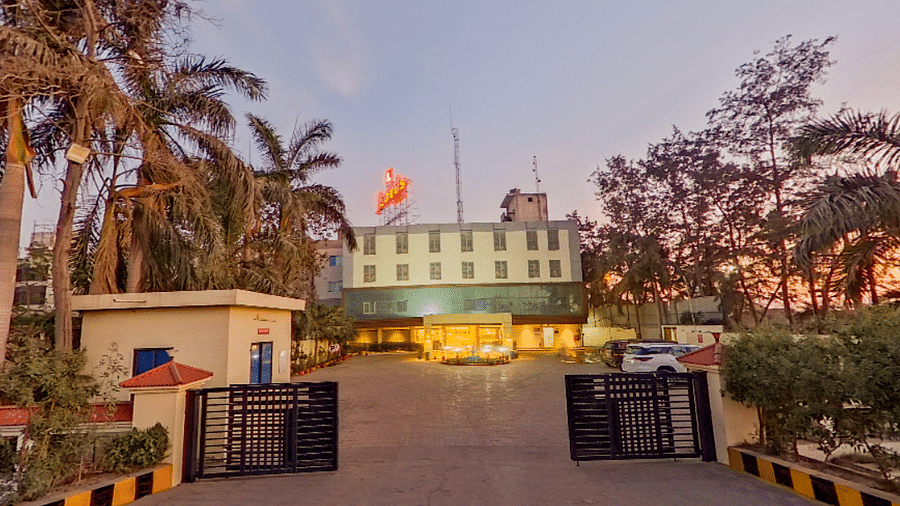 Exterior view of Lords Eco Inn Dahej at sunset showing hotel entrance, landscaped gardens, palm trees, and welcoming facade with signage