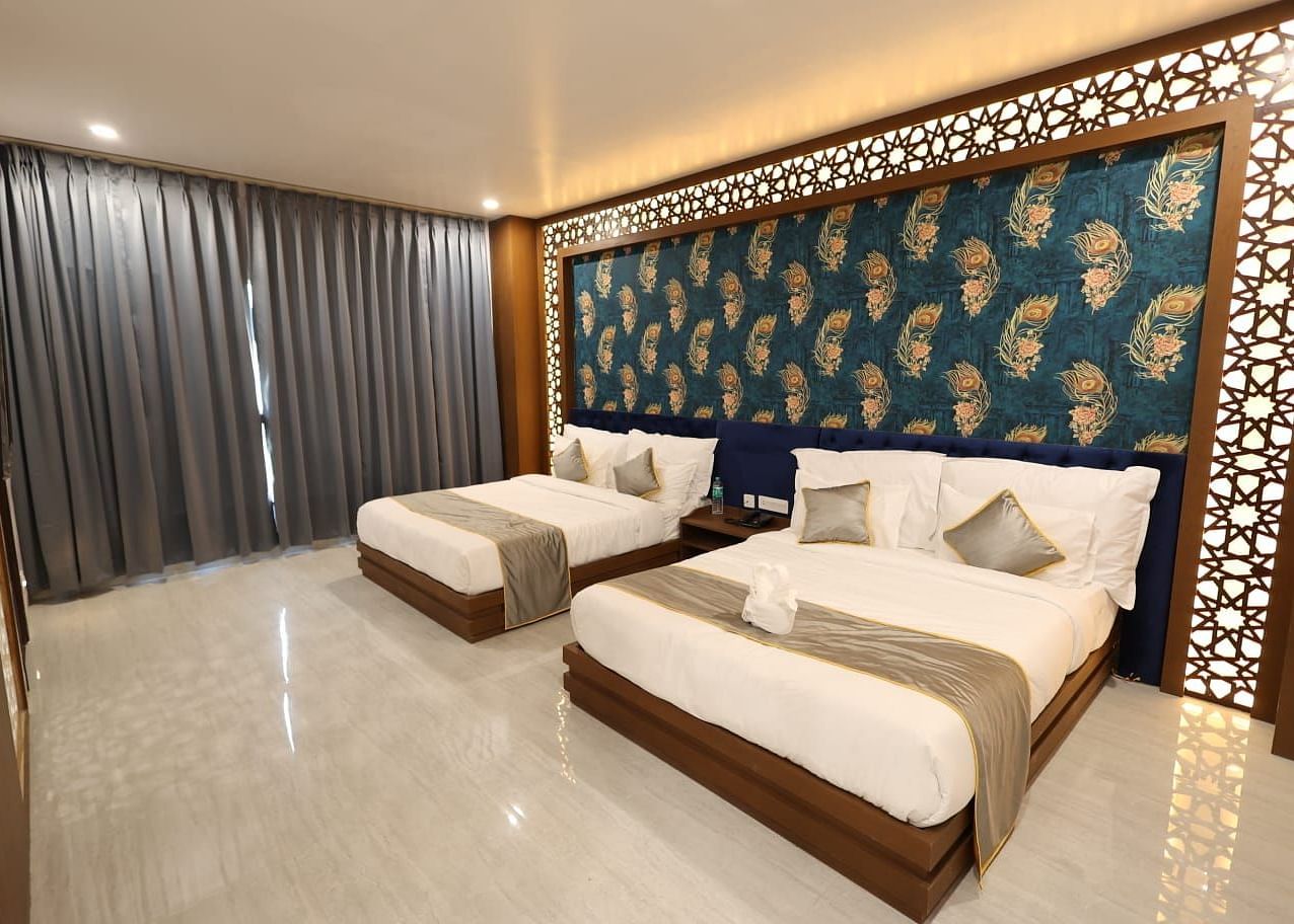 A room with twin beds and a textured accent wall at Bamboo Saa Mulberry Resort, Pushkar