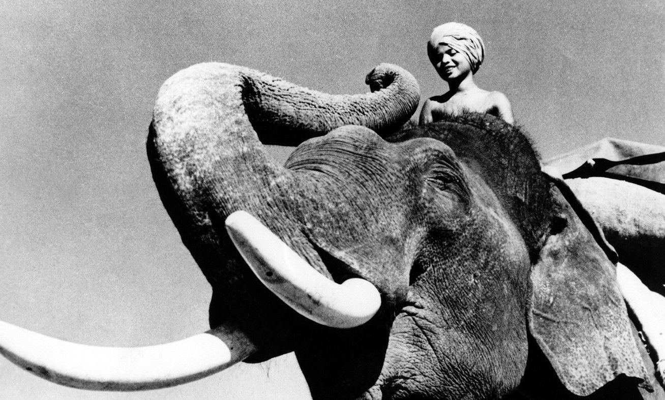 Young boy Sabu riding an elephant in the 1937 film.