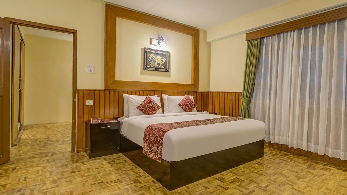 Image of a room with bed and large windows at Summit Tashi Ghang Heritage Resort, Pelling