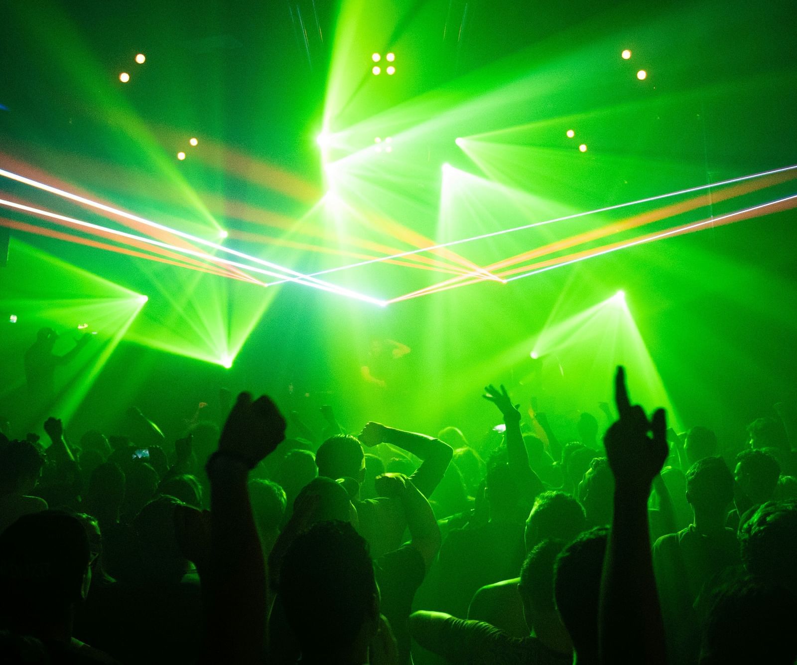 An image of people dancing under the disco lights in a club