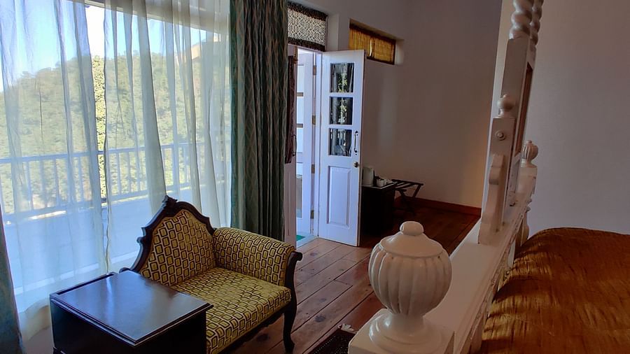 Premium room with bed and sofa in front of the bed at Bed with side canopy and a lamp on the side of the bed at 3 bhk cottage at Te Aroha by Shervani Mukteshwar