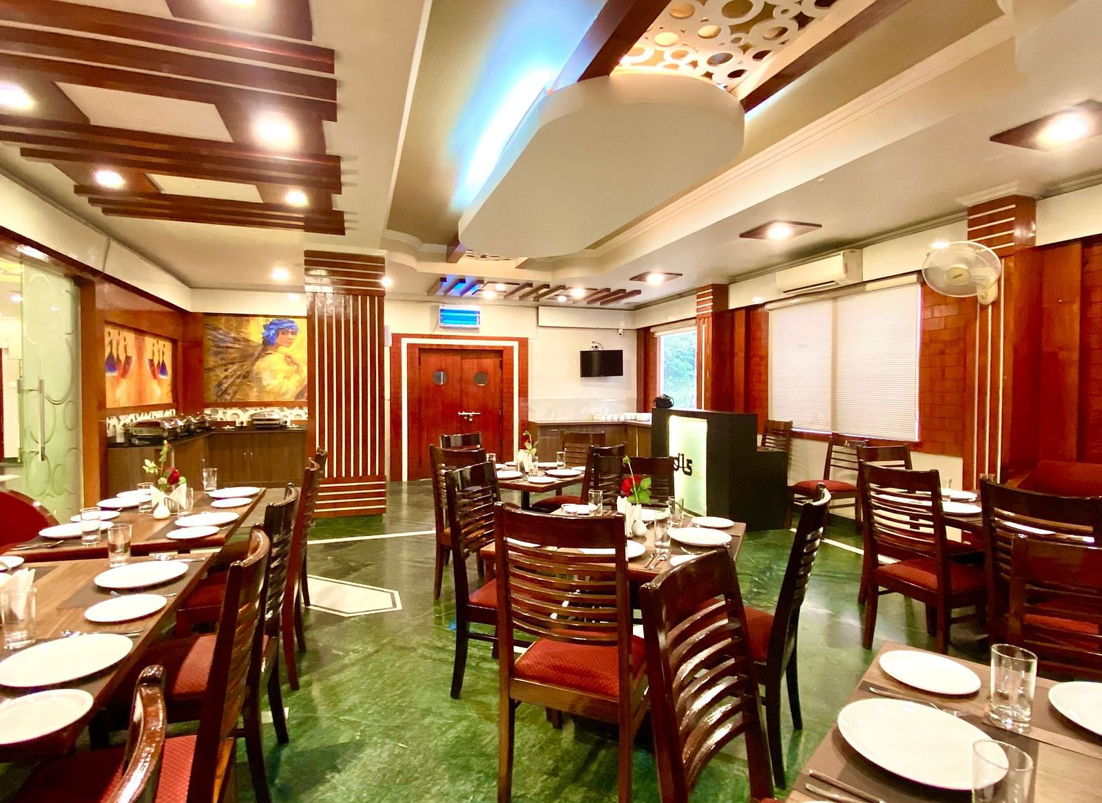 Dining area at DLS Park Grace, Haridwar featuring ample seating area, assorted plates, and bright  lighting.