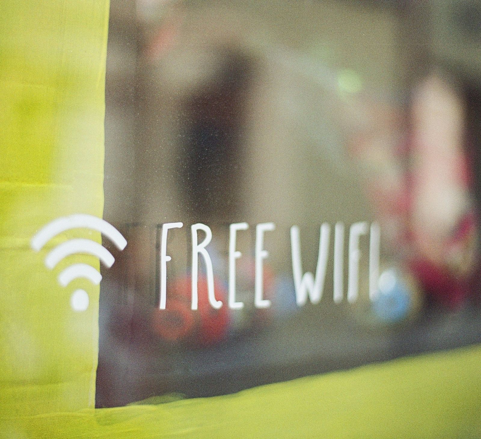 A blurry image of a window with the text free Wi-Fi written on it, indicating availability of complimentary internet service
