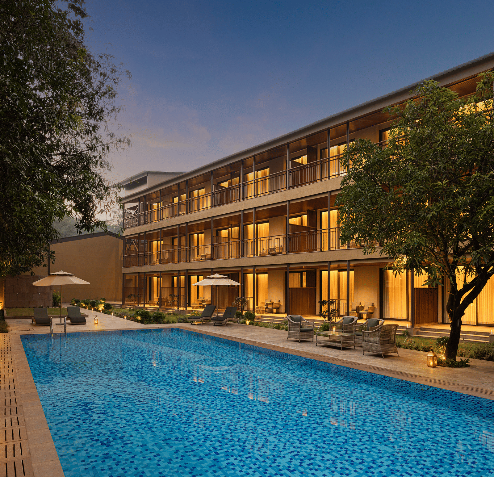 Sanctuary Block exterior and illuminated swimming pool at The Riverview Retreat, Corbett, during the evening.