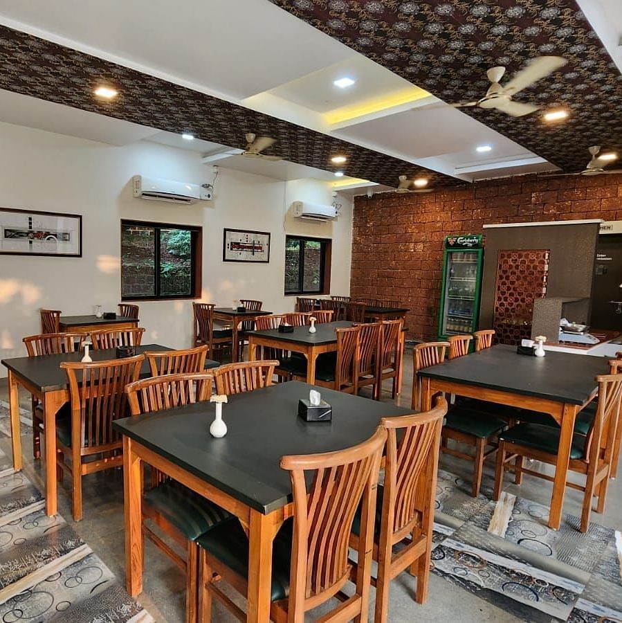 A diagonal view of the restaurant with wooden tables and chairs arranged neatly, and tables set for the guests at SeaFort Beach Resort