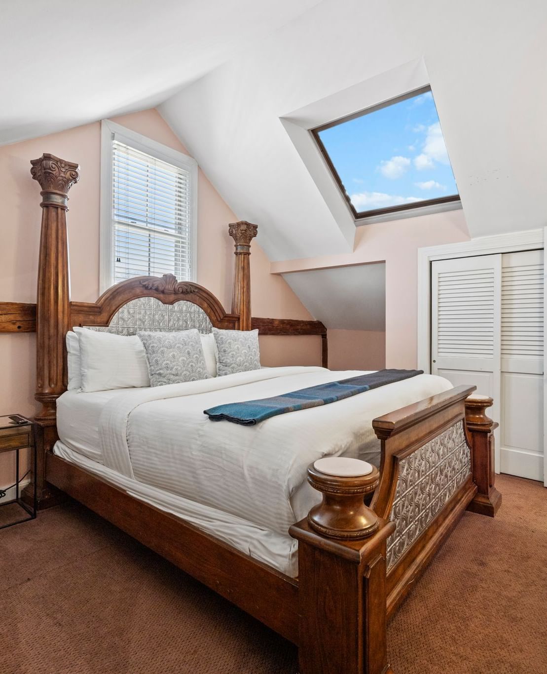 A bedroom with four-poster bed, flat screen TV, and traditional furnishings at Hartstone Inn