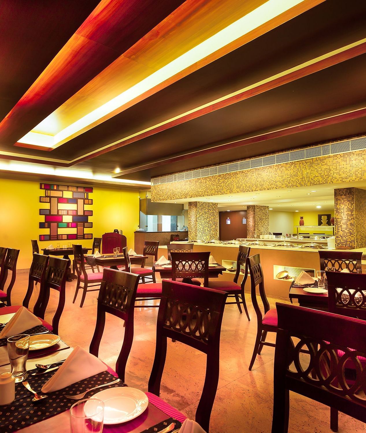 An image of a dining space with tables and chairs at Regency Madurai by GRT Hotels