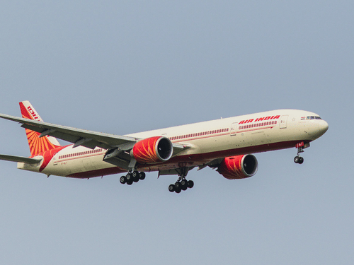A view of flight by Air India, in the air with blue sky in the background.