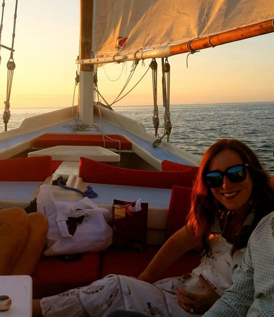 Three people sitting on a sailboat at sunset near Casa Morada, our resort in Islamorada.