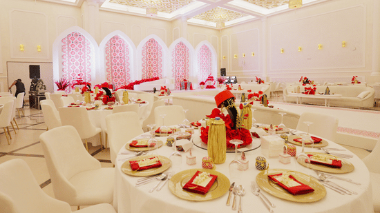 An elegantly decorated banquet hall at La Maison, Doha, with round tables set for a formal event.