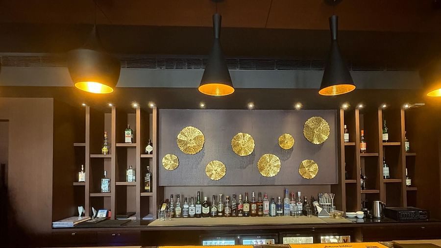 A bar with overhead pendant lights and a decorative back wall, focusing on the lighting and decorative elements.