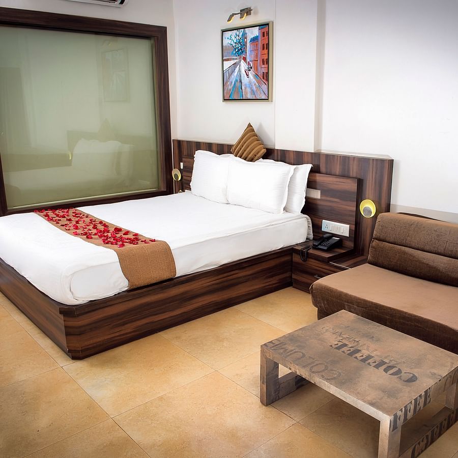 Adamo Resort Matheran - Regent Room with a sofa beside the bed