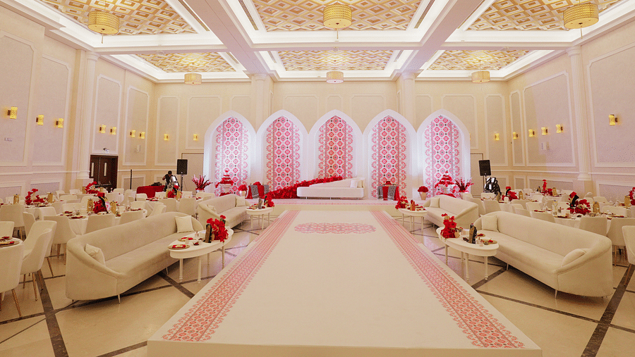 A wide view of a decorated banquet hall at La Maison, Doha, featuring a patterned ceiling and arched doorways.