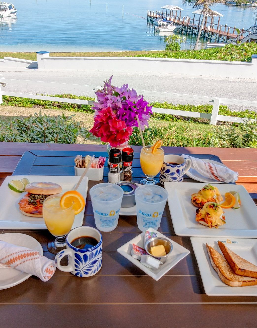 Breakfast plates on a wooden table near the sea | Abaco Inn