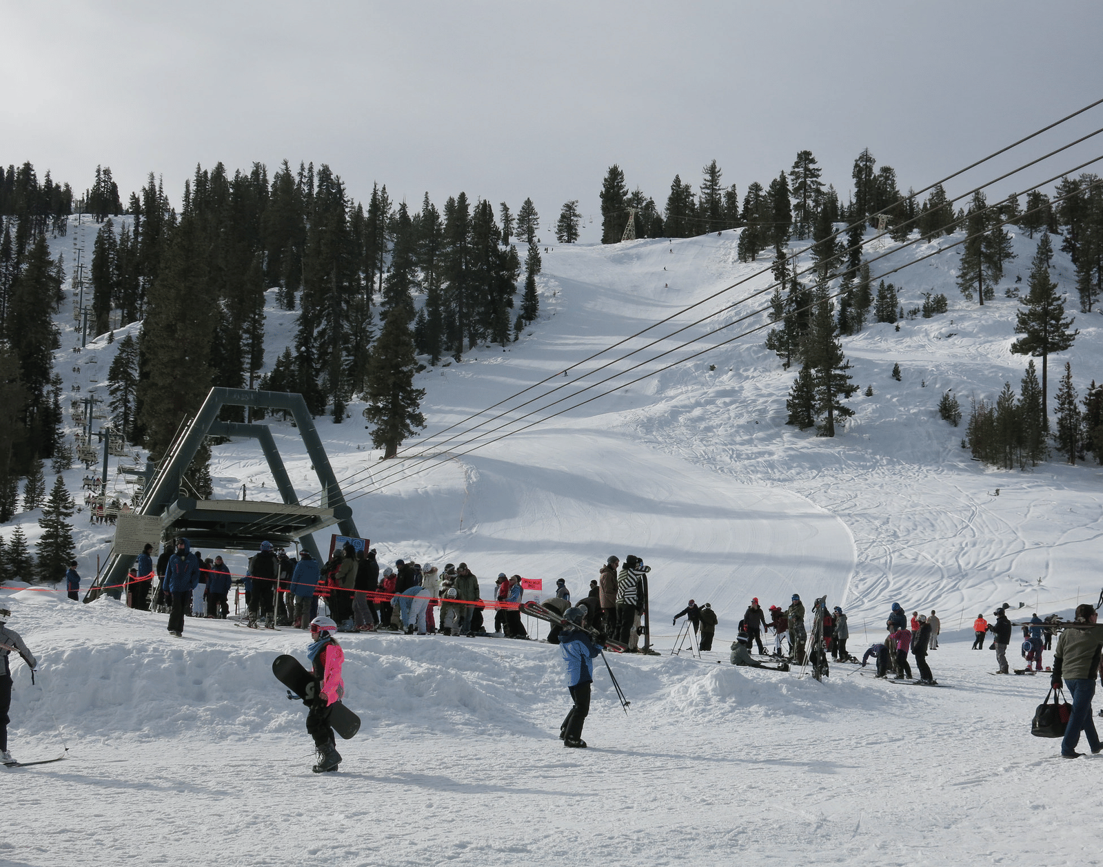People skiing on a snowy mountain on an overcast day.