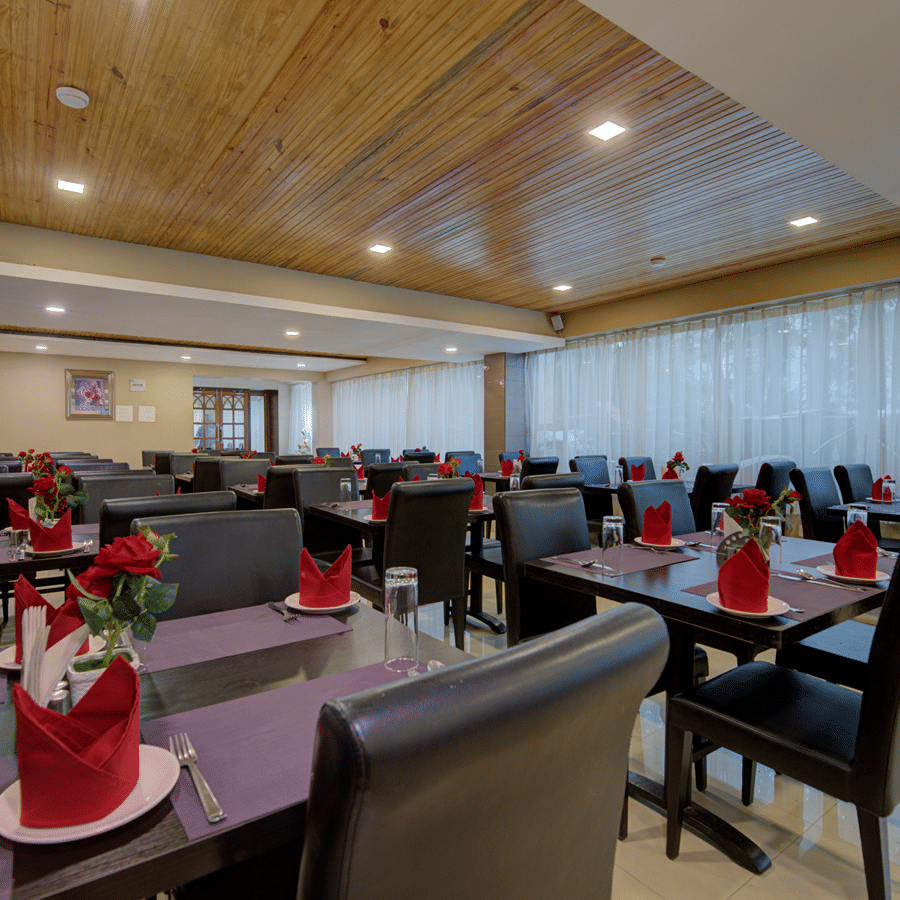Wild Orchid, the multi-cuisine restaurant at Central Courtyard Boutique Hotel, Siliguri, featuring empty tables and chairs organised