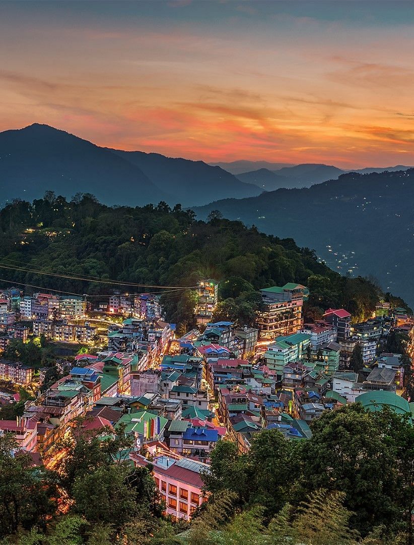 Aerial view of a town with mountains in the background.