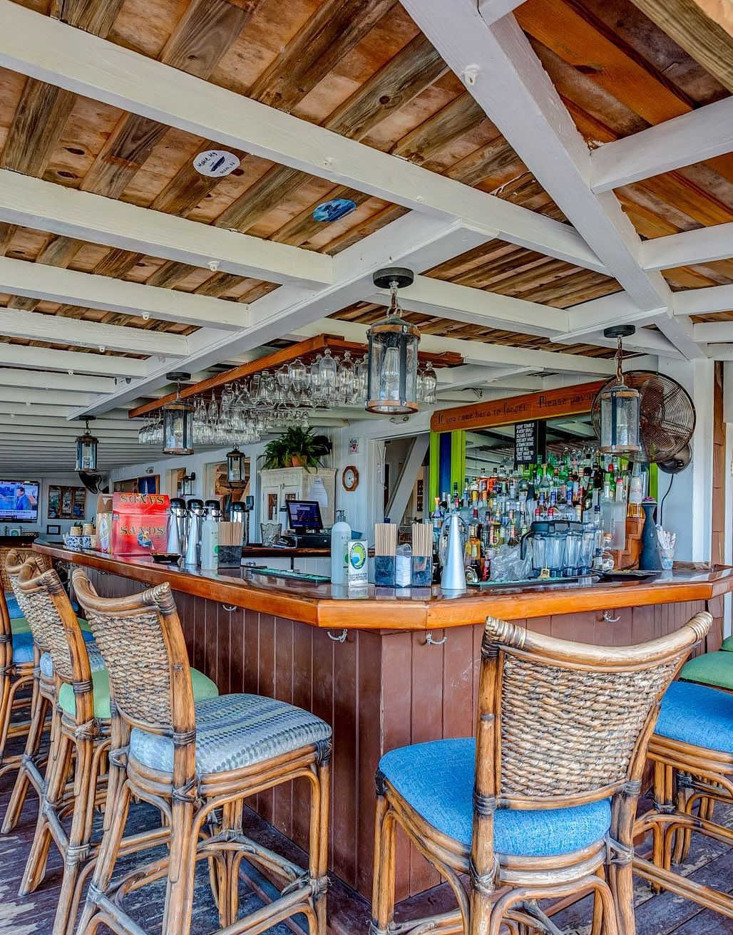 Bar counter with high chairs and wooden ceiling inside the dining area | Abaco Inn