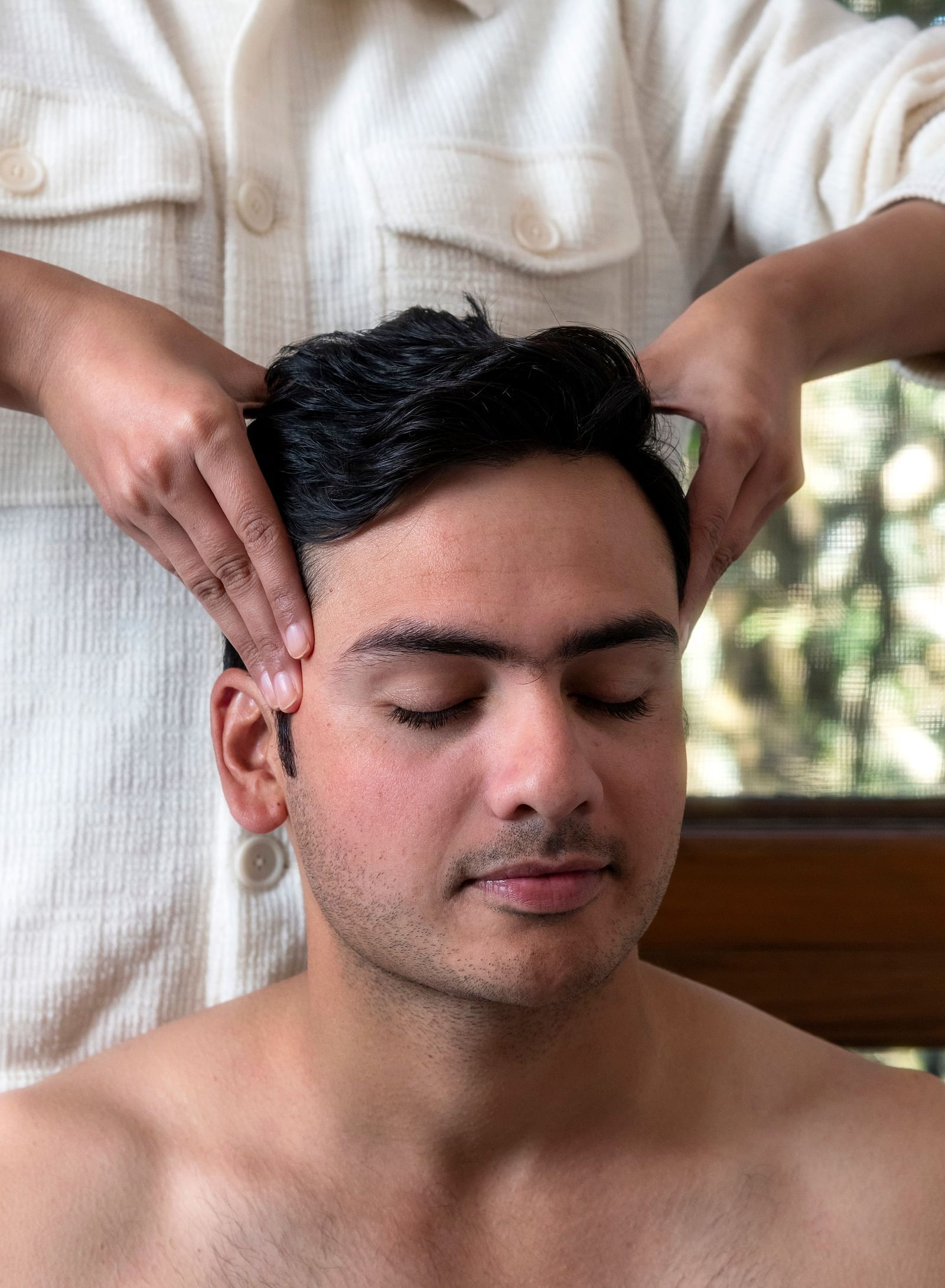 a person getting a head message at The Claridges Nabha Residence