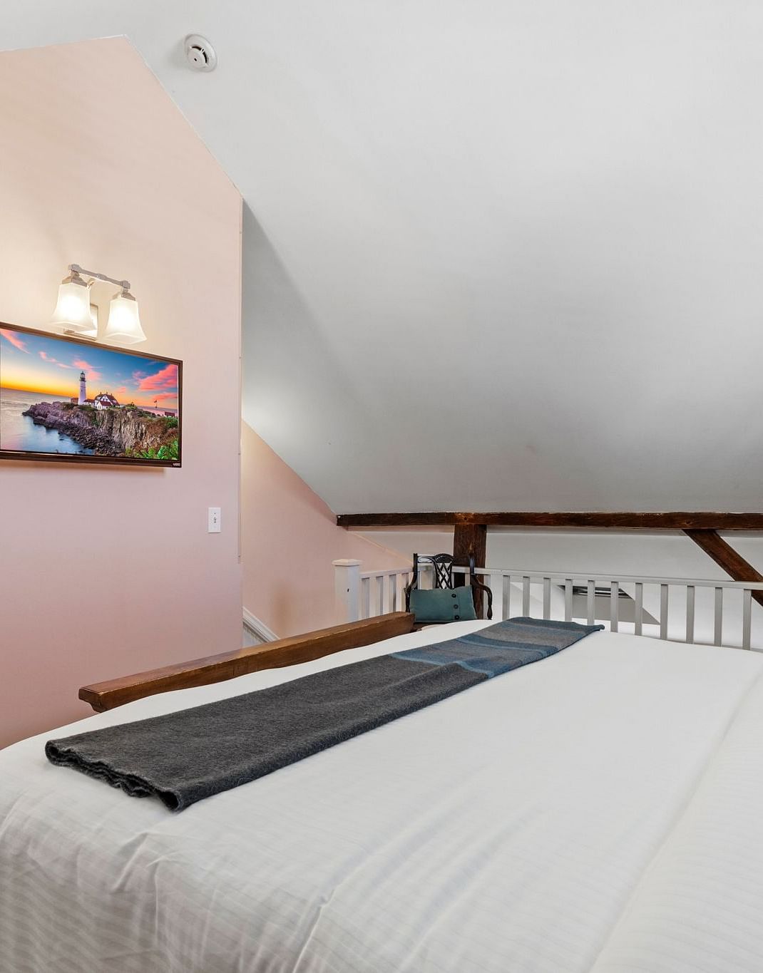 A room with sloped ceiling, compact vanity, and neutral decor at Hartstone Inn