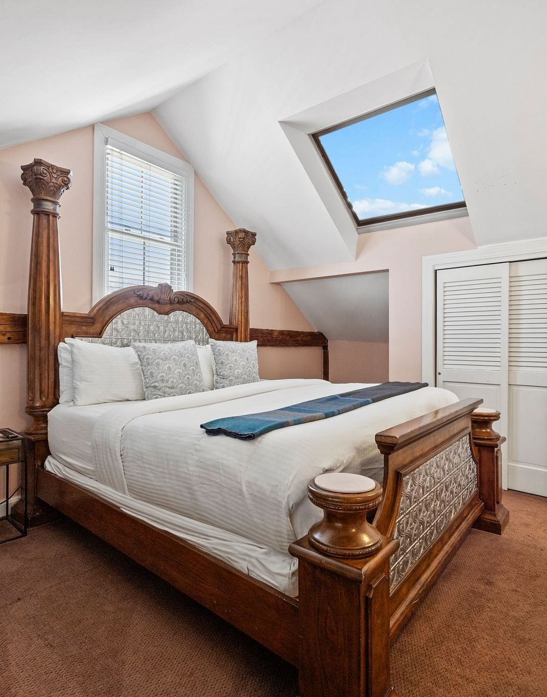 A bedroom with four-poster bed, flat screen TV, and traditional furnishings at Hartstone Inn