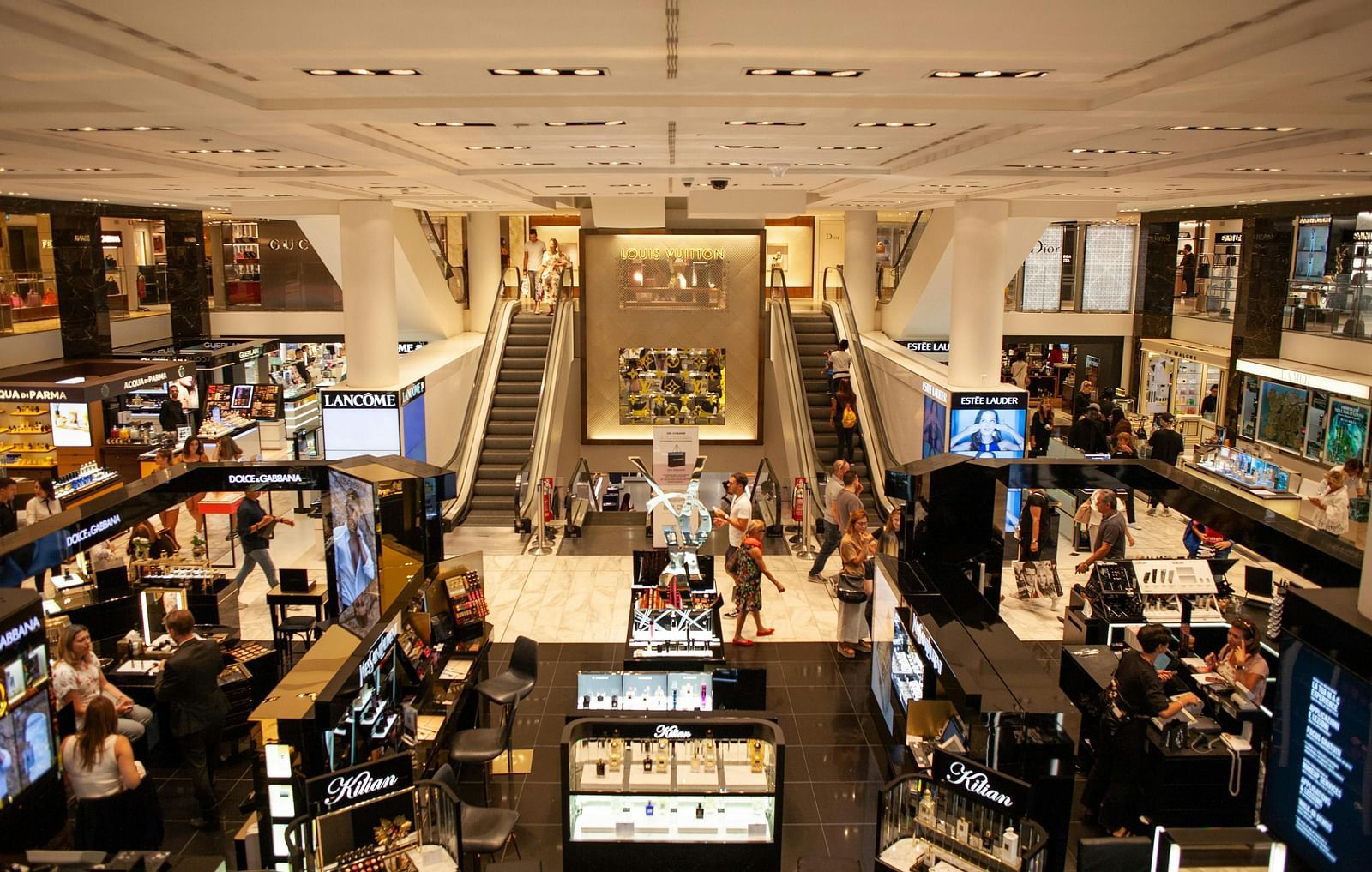 Interior view of a mall with multiple levels, escalators, and various counters.