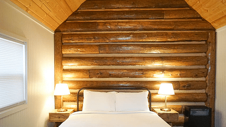 A room with a double bed and side tables with night lights at Shaver Lake Village Hotel.
