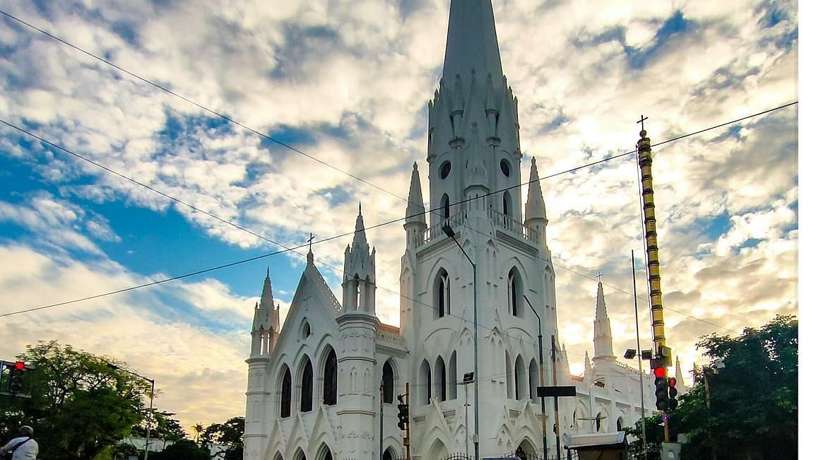 Facade of Santhome Church with a cloudy sky in the background.