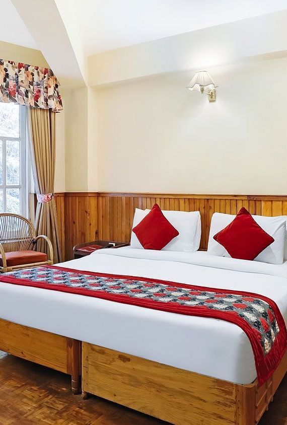 A full view of a room that has a bed and a huge glass window | Summit Newa Regency & Spa, Pelling