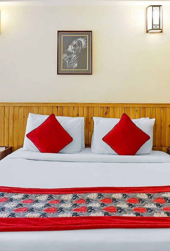A front view of the beds placed in a room that has a glass window | Summit Newa Regency & Spa, Pelling