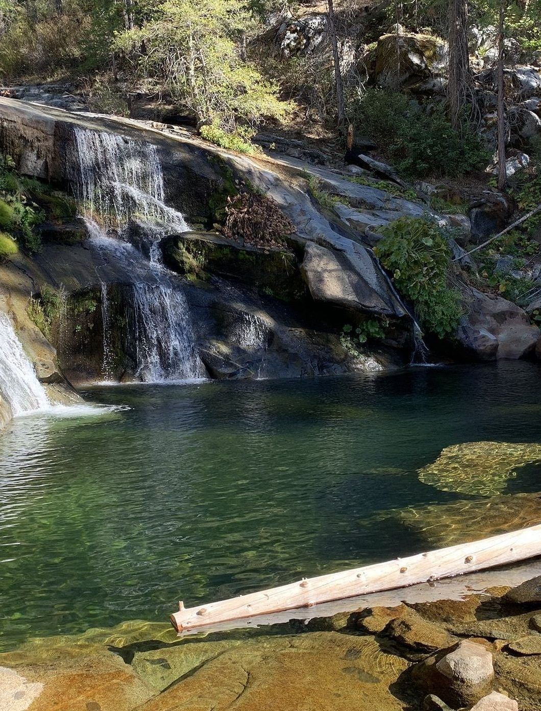 water flowing into a serene pond at Carlon Falls, surrounded by lush trees