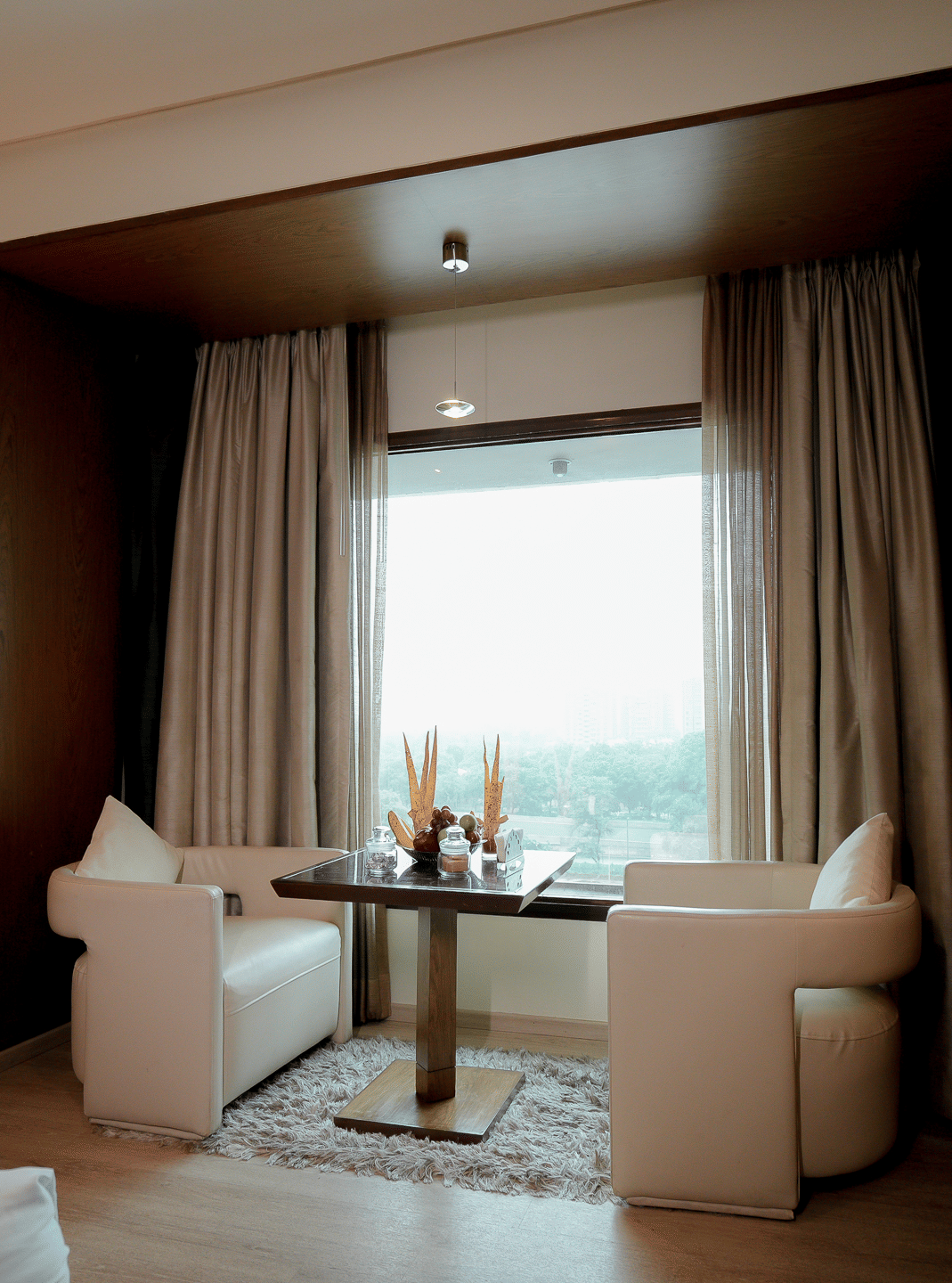 Chic sitting area with two chairs and a coffee table by the window – Narayani Heights Hotel & Resorts