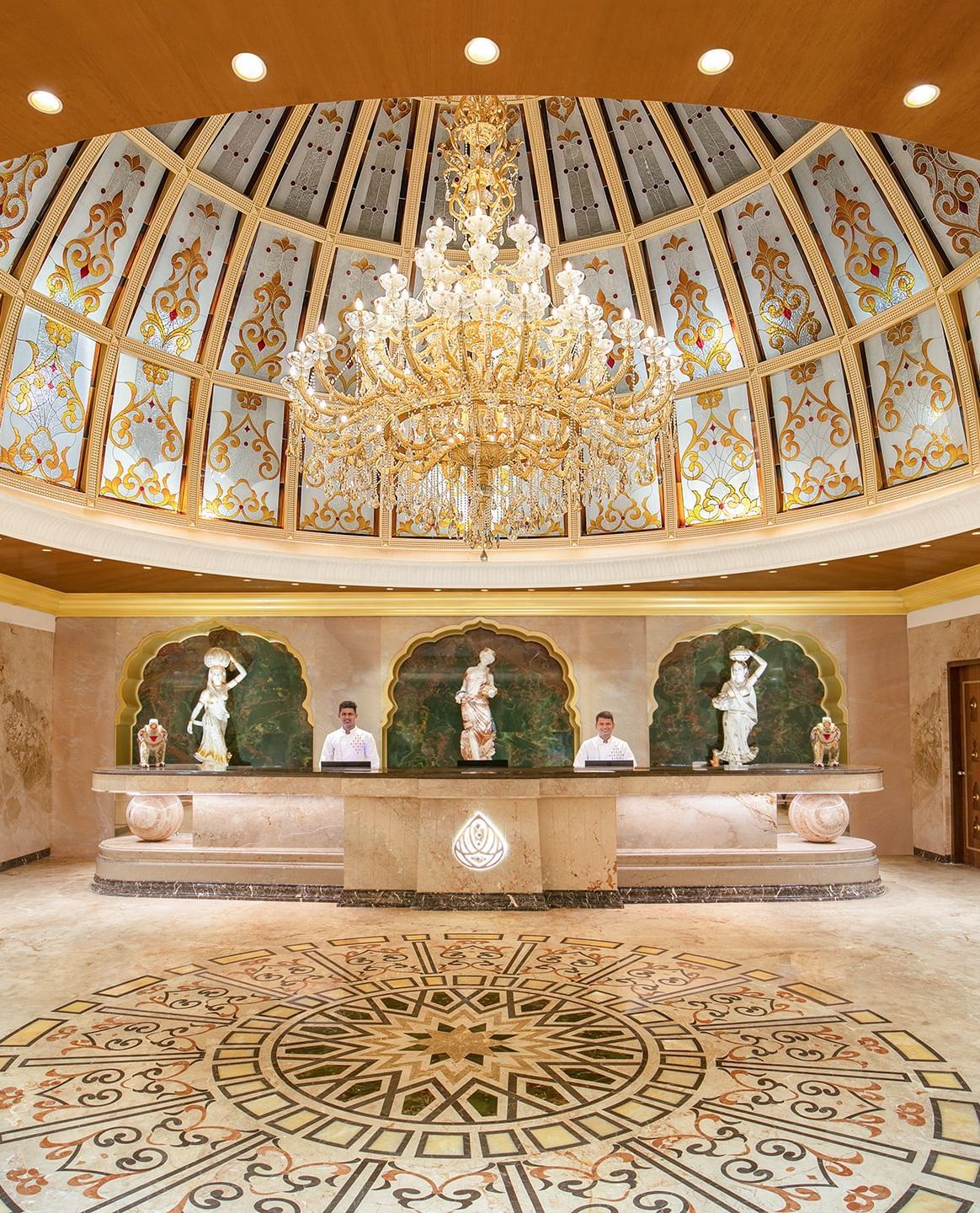 A reception area with a reception desk, receptionists and a giant chandelier - Kaldan Samudhra Palace
