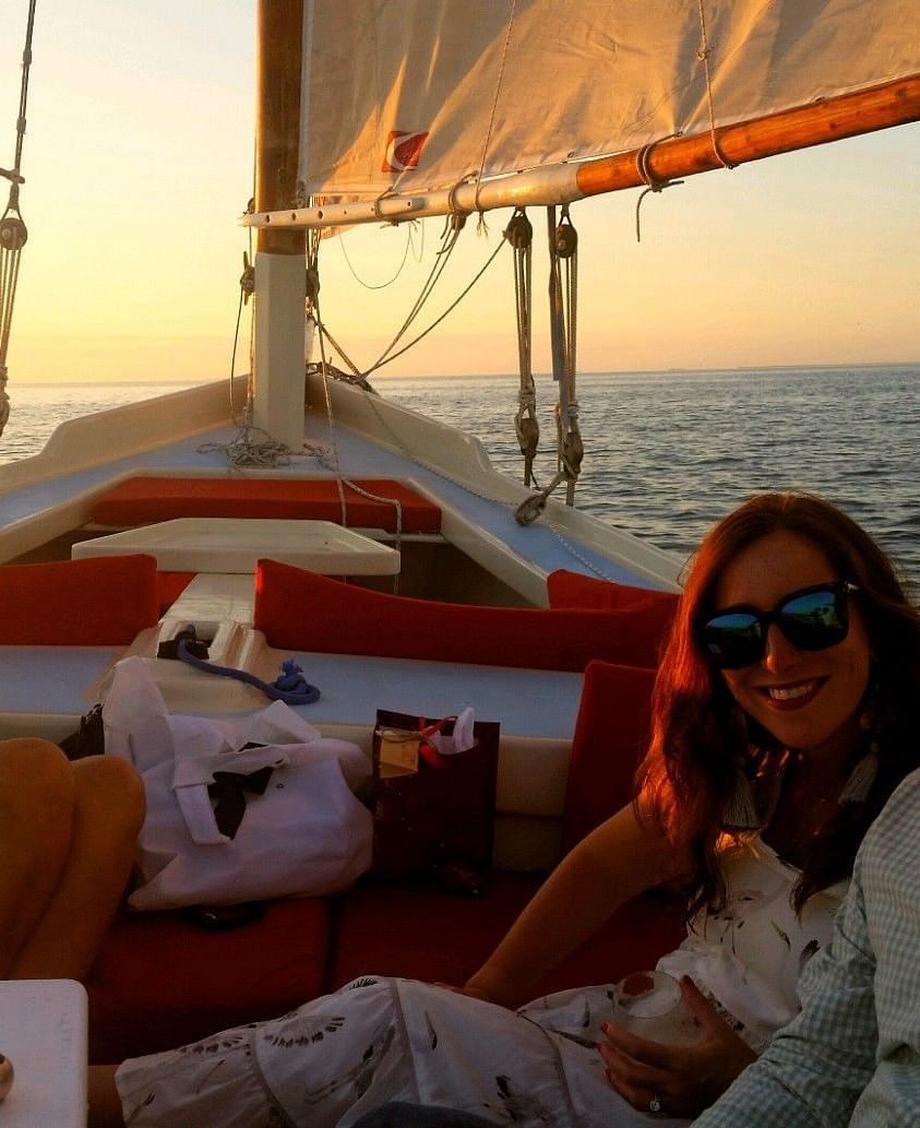 Three people sitting on a sailboat at sunset near Casa Morada, our resort in Islamorada.