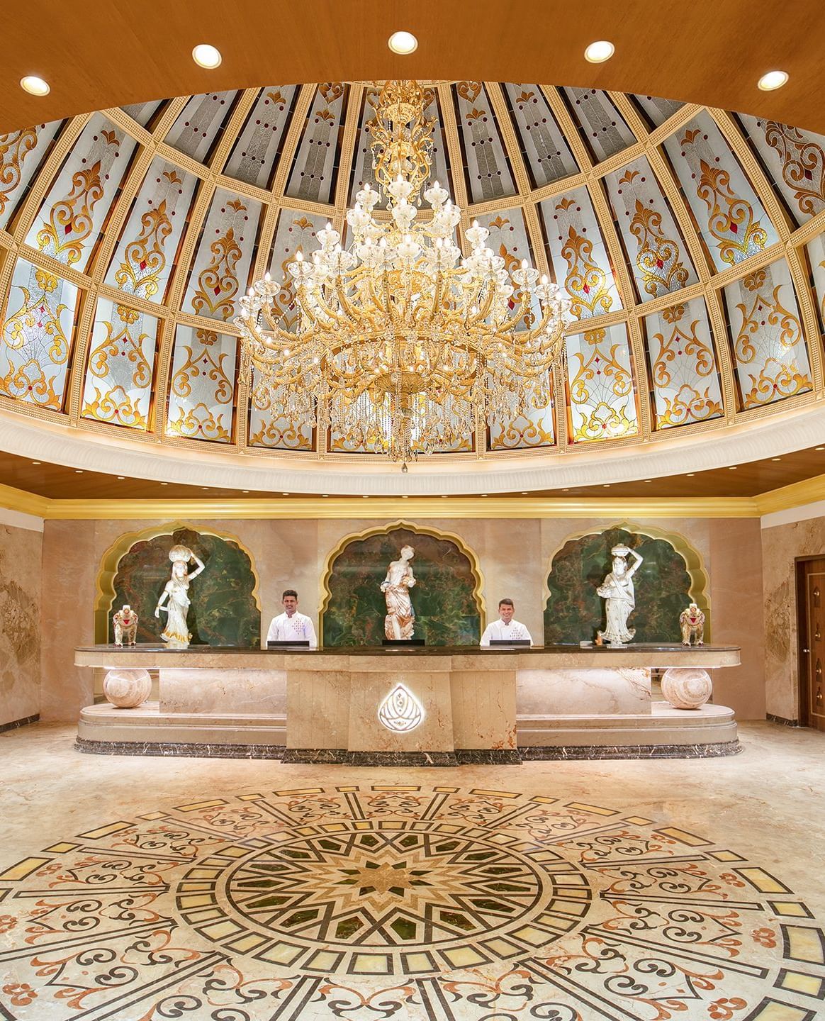 A reception area with a reception desk, receptionists and a giant chandelier - Kaldan Samudhra Palace
