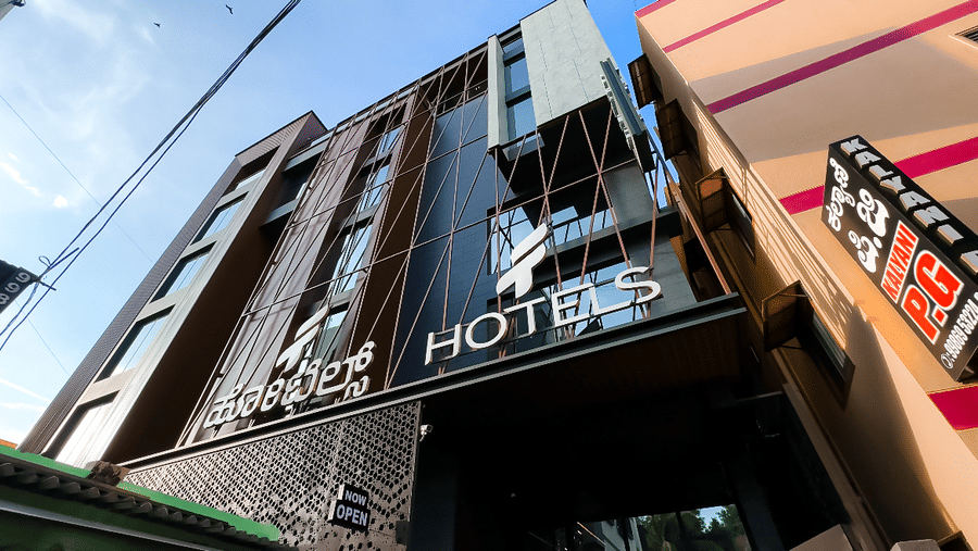 The entrace of F Hotels, Bengaluru, featuring its signboard outside the building.