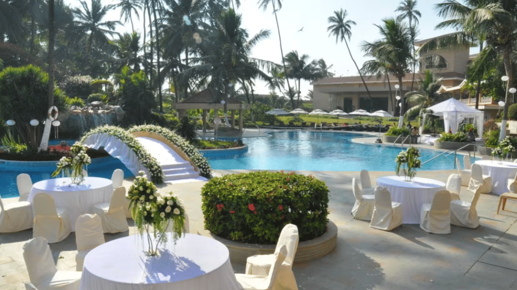 A serene poolside venue adorned with elegant seating creating a perfect tropical setting for intimate weddings and celebrations by the water.