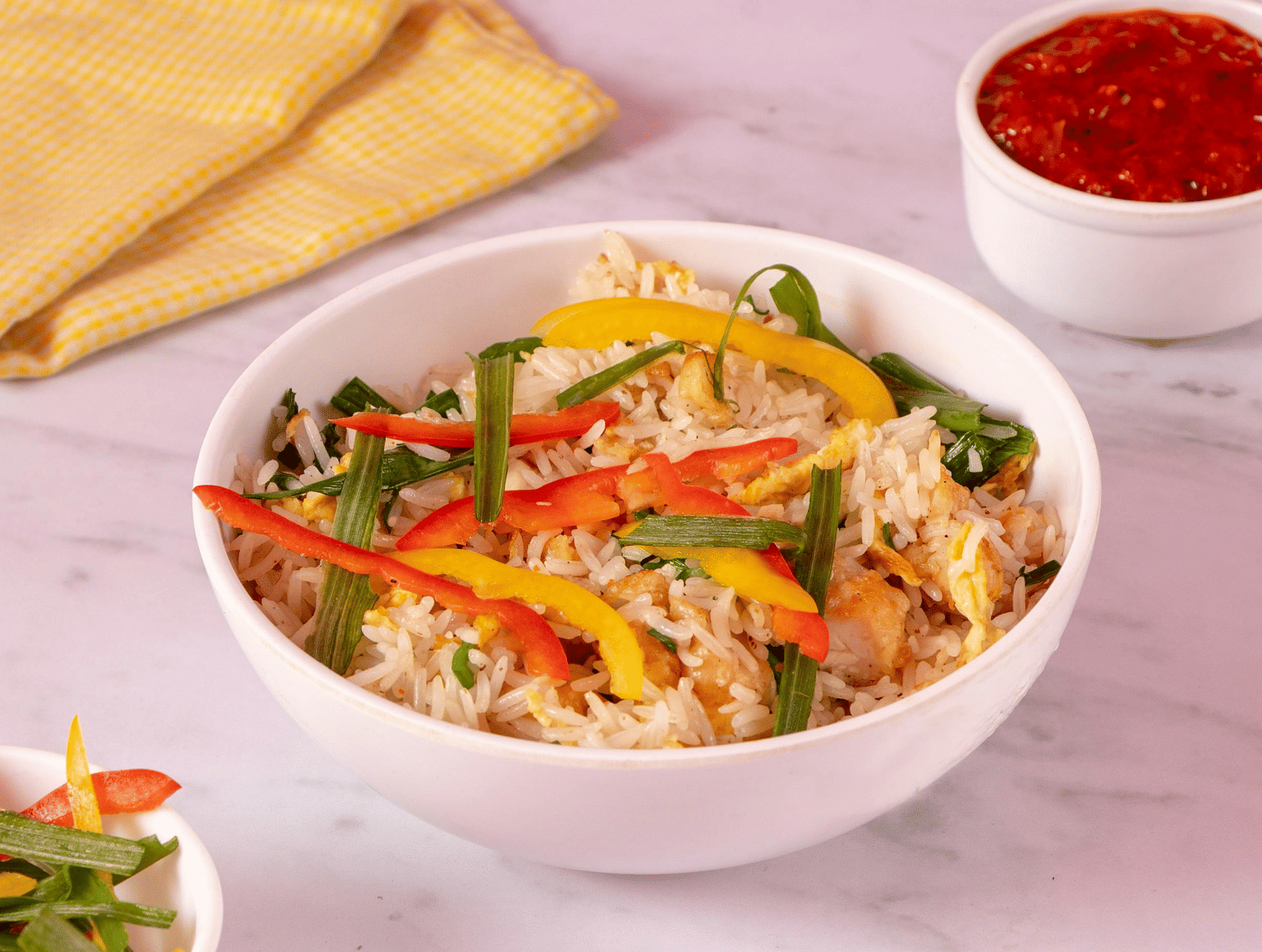 A bowl of fried rice garnished with sliced bell peppers.