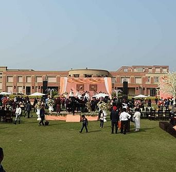 An open air setting with people gathered for an event at Nirvana Luxury Hotel, Ludhiana.
