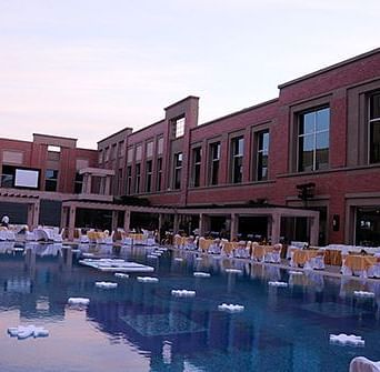 An open-air event with comfortable chairs placed around tables at Nirvana Luxury Hotel, Ludhiana.
