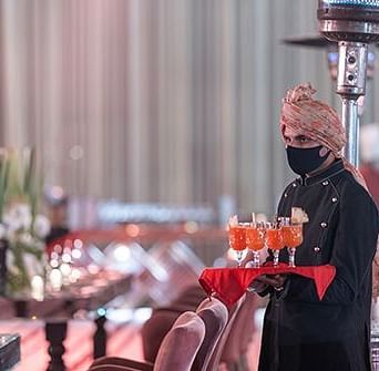 A waiter holding a plate of trays at an event at Nirvana Luxury Hotel, Ludhiana.