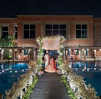 A couple posing for a picture in a wedding hall at A lavish decoration of  wedding celebration at Nirvana Luxury Hotel, Ludhiana. 
