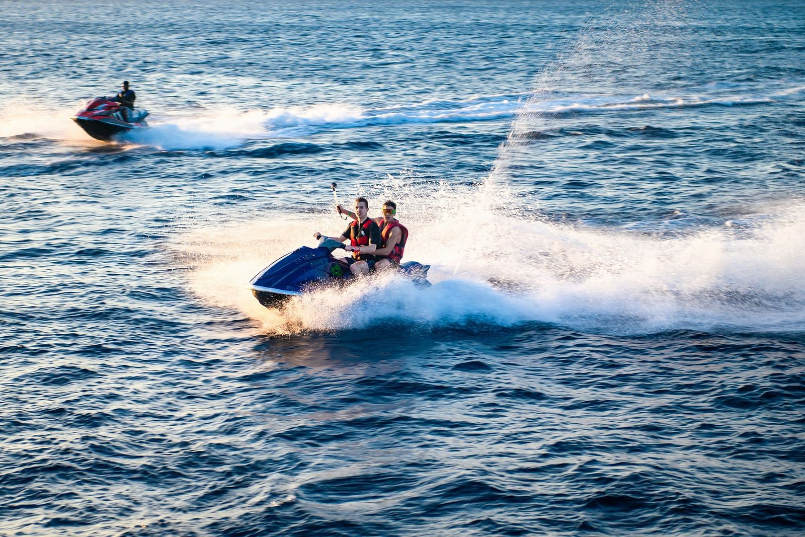 Jet skiers riding the waves, with intense action and ocean spray