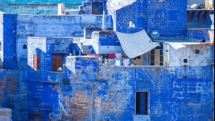 A detailed, abstract photo of the blue-washed walls of houses in the city of Chefchaouen, Morocco.