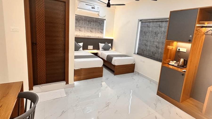 View of a bedroom with two beds, an open wardrobe, and tiled flooring | Hotel Aurora Bliss