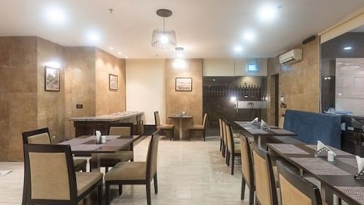 Chairs and round tables at a restaurant | Hotel Mumbai House, Andheri East